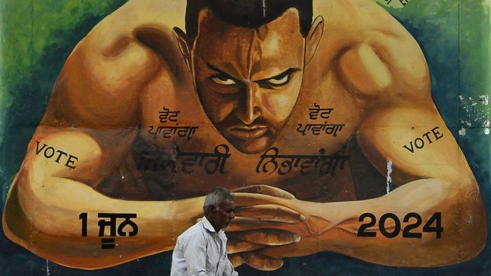 Egy férfi kerékpárral megy el egy falfestmény mellett, amely Aamir Khan bollywoodi színészt ábrázolja, és az embereket szavazatadásra buzdító szlogenekkel száguldozik Jalandharban