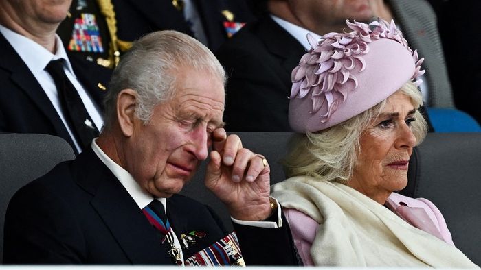 Károly brit király és Kamilla királynő meghatódva nézik a megemlékezést