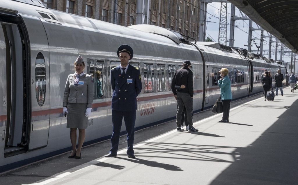 Employees of the high speed electric train Sapsan, connecting St.Petersburg and Moscow wait for passengers at Moskovsky railway station in St.Petersburg on June 22, 2017. (Photo by Mladen ANTONOV / AFP)