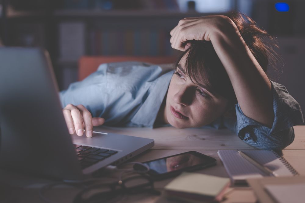 Sleepy,Exhausted,Woman,Working,At,Office,Desk,With,Her,Laptop,