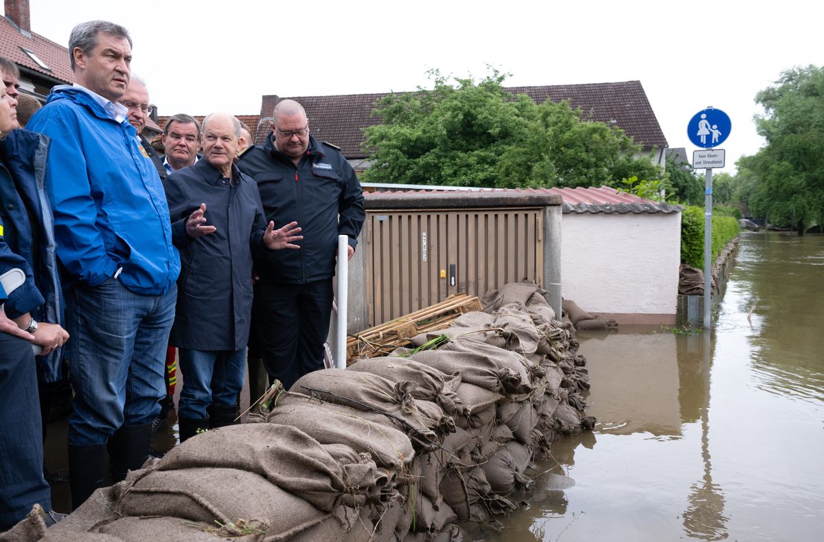 03 June 2024, Bavaria, Reichertshofen: Federal Chancellor Olaf Scholz (SPD) and Bavaria's Prime Minister Markus Söder (l, CSU) stand behind a barrier made of sandbags during a site inspection in Reichertshofen, Upper Bavaria, which was hit by flooding. Many places in Bavaria are still flooded after heavy rainfall. Photo: Sven Hoppe/dpa (Photo by SVEN HOPPE / DPA / dpa Picture-Alliance via AFP)