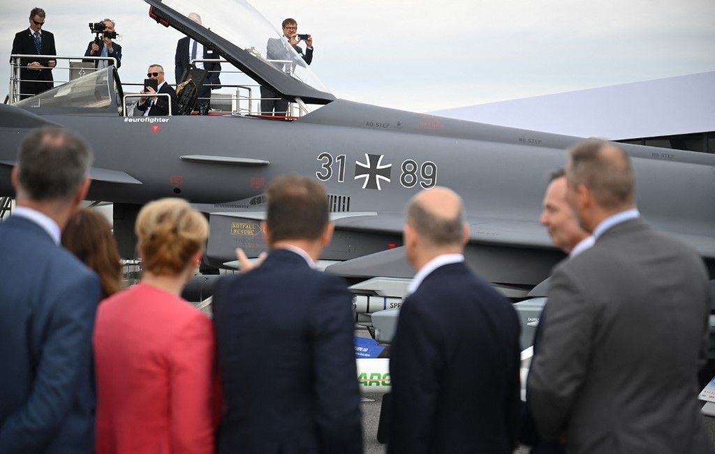 Újabb Eurofighter harci repülőket vásárol Olaf Scholz a német hadseregnek 05 June 2024, Brandenburg, Schönefeld: Federal Chancellor Olaf Scholz (SPD,M,r), stands in front of a Eurofighter during the opening tour of the International Aerospace Exhibition (ILA) on the grounds of Berlin Brandenburg Airport (BER) with Franziska Giffey (SPD, M), Berlin Senator for Economics, Energy and Public Enterprises, and Volker Wissing (FDP, r), Federal Minister of Transport and Digital Affairs, among others. The trade fair will take place from June 5 to 9, 2024 under the motto "Pioneering Aerospace". Photo: Sebastian Christoph Gollnow/dpa (Photo by Sebastian Gollnow / DPA / dpa Picture-Alliance via AFP)