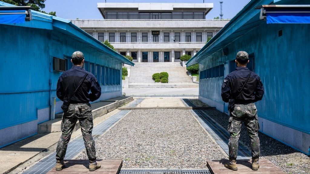 In this photo taken on May 9, 2023, South Korean soldiers stand guard as they face North Korea's Panmon Hall (back) at the truce village of Panmunjom in the Joint Security Area (JSA) of the Demilitarized Zone (DMZ) separating North and South Korea. South Korea and Japan's efforts to improve their once-strained relationship and boost military ties are key to countering North Korea, America's top general said. (Photo by Anthony WALLACE / AFP)