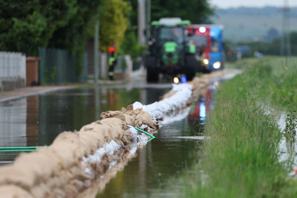 03 June 2024, Bavaria, Asbach-Bäumenheim: Helpers from the fire department lay a barrier with sandbags to protect a residential area from flooding. Photo: Karl-Josef Hildenbrand/dpa (Photo by KARL-JOSEF HILDENBRAND / DPA / dpa Picture-Alliance via AFP)