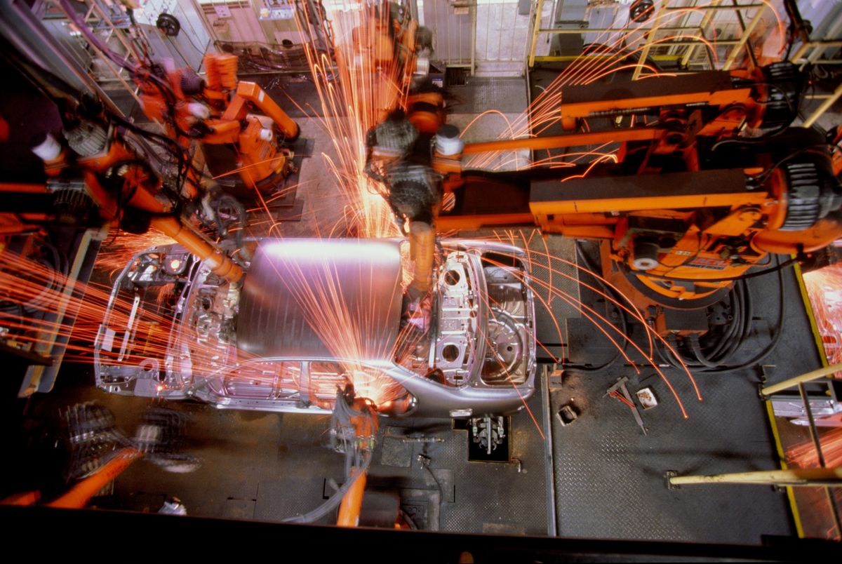 Car assembly line, robotic welding on car body, overhead view
csehország