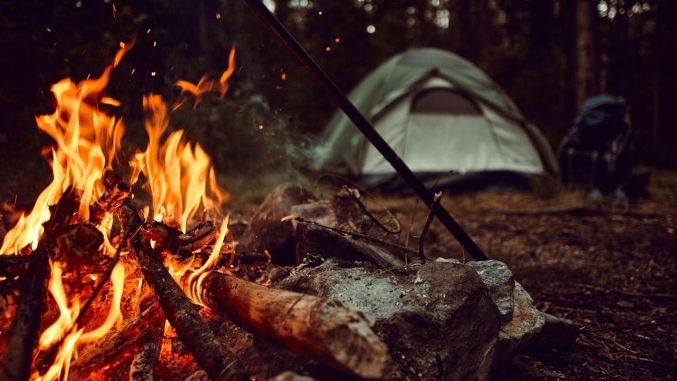 Evening,Campfire,In,The,Woods,With,Tent,And,Backpack,In