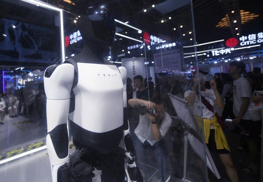 Visitors are visiting the second generation Optimus humanoid robot introduced by Tesla at the 2024 World Artificial Intelligence Conference in Shanghai, China, on July 4, 2024. (Photo by Costfoto/NurPhoto) (Photo by CFOTO / NurPhoto / NurPhoto via AFP)