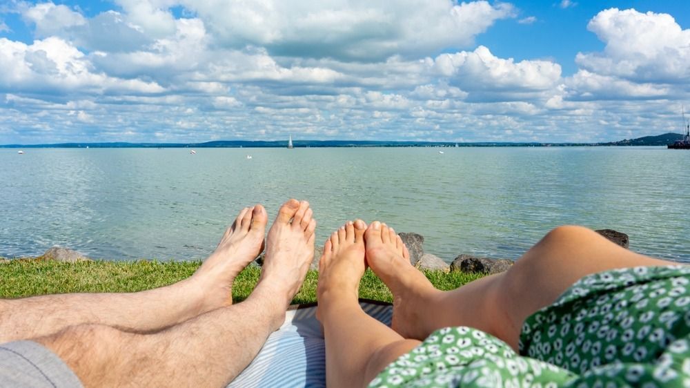 Couple,Hanging,Out,Chilling,On,A,Blanket,Next,To,Lake