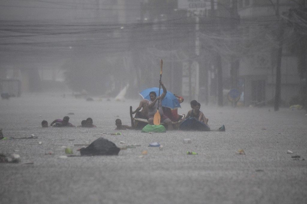 Rescuers paddle their boats along a flooded street in Manila on July 24, 2024 amid heavy rains brought by Typhoon Gaemi. Relentless rain drenched the northern Philippines on July 24, triggering flooding in Manila and landslides in mountainous regions as Typhoon Gaemi intensified the seasonal monsoon. (Photo by Ted ALJIBE / AFP)