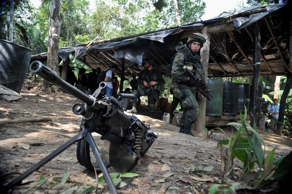 Antinarcotics police officers prepare charges to blow up a laboratory for processing cocaine base seized from the Revolutionary Armed Forces of Colombia (FARC) in the municipality of Puerto Concordia, Meta department, Colombia, on January 25, 2011. AFP PHOTO/Guillermo Legaria (Photo by GUILLERMO LEGARIA / AFP)