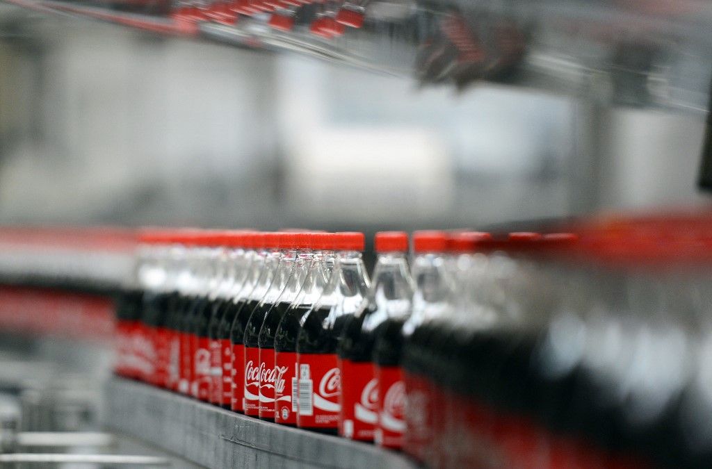 Coca-Cola bottles are pictured on the production line in the bottling plant of the Coca-Cola Erfrischungsgetränke AG production facility in Genshagen, Germany, 21 August 2013. Here, Coca-Cola products are filled into disposable packaging on 158,000 square meters. 170 employees work in the production facility, which was opened in 1998. The Coca-Cola Erfrischungsgetränke AG is one of the biggest beverage companies in Germany with a sales volume of 3.7 billion liters in 2012. Photo: Jens Kalaene (Photo by JENS KALAENE / ZB / dpa Picture-Alliance via AFP)