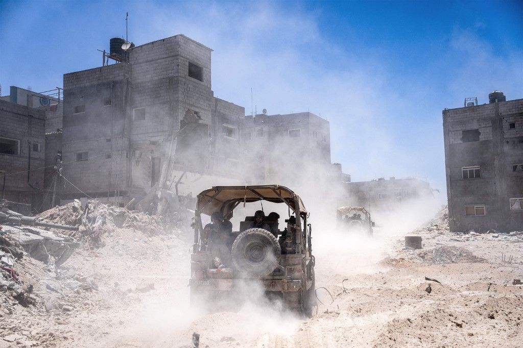 Israeli army vehicles transport a group of soldiers and journalists inside the southern Gaza Strip on July 3, 2024. The Israeli military invited reporters for a tour of Rafah, where the military has been operating since May 6. (Photo by Ohad Zwigenberg / POOL / AFP)