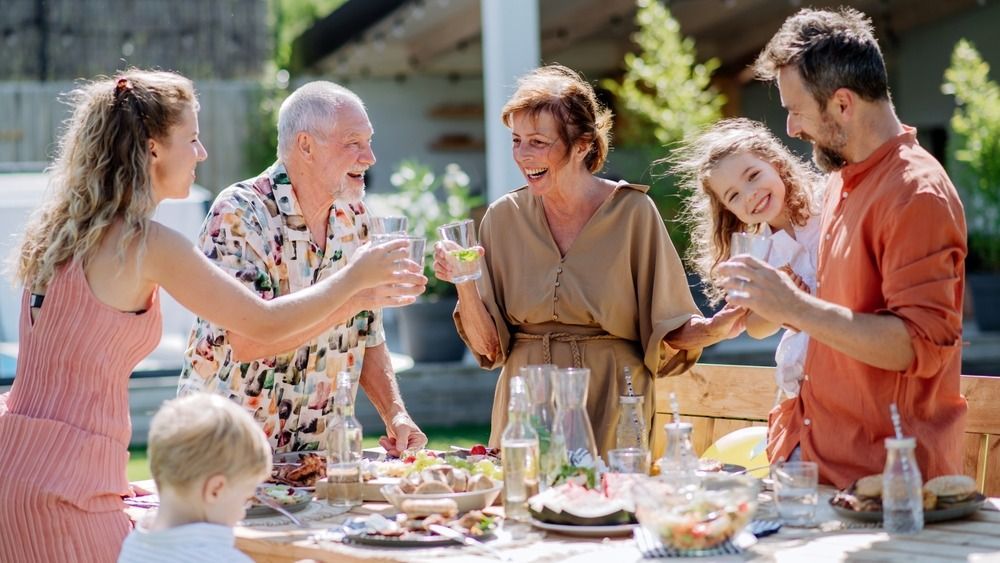 Multi,Generation,Family,Having,Garden,Party,Celebration,,Toasting,And,Laughing.