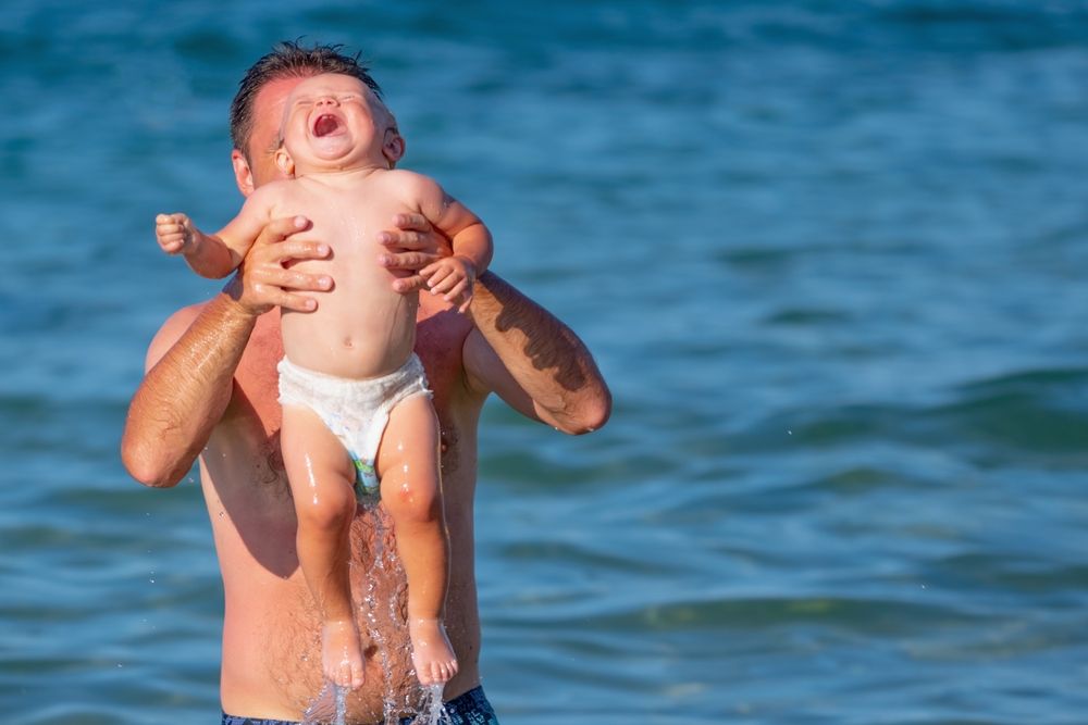 Funny,Portrait,Of,Baby,Child,With,Father,In,The,Sea.