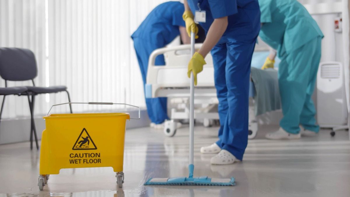 Nurses,Mopping,Floor,And,Making,Bed,In,Empty,Hospital,Ward.