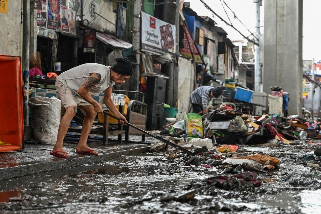 Residents clean their houses in the aftermath of Typhoon Gaemi in Manila on July 25, 2024. (Photo by Jam Sta Rosa / AFP)