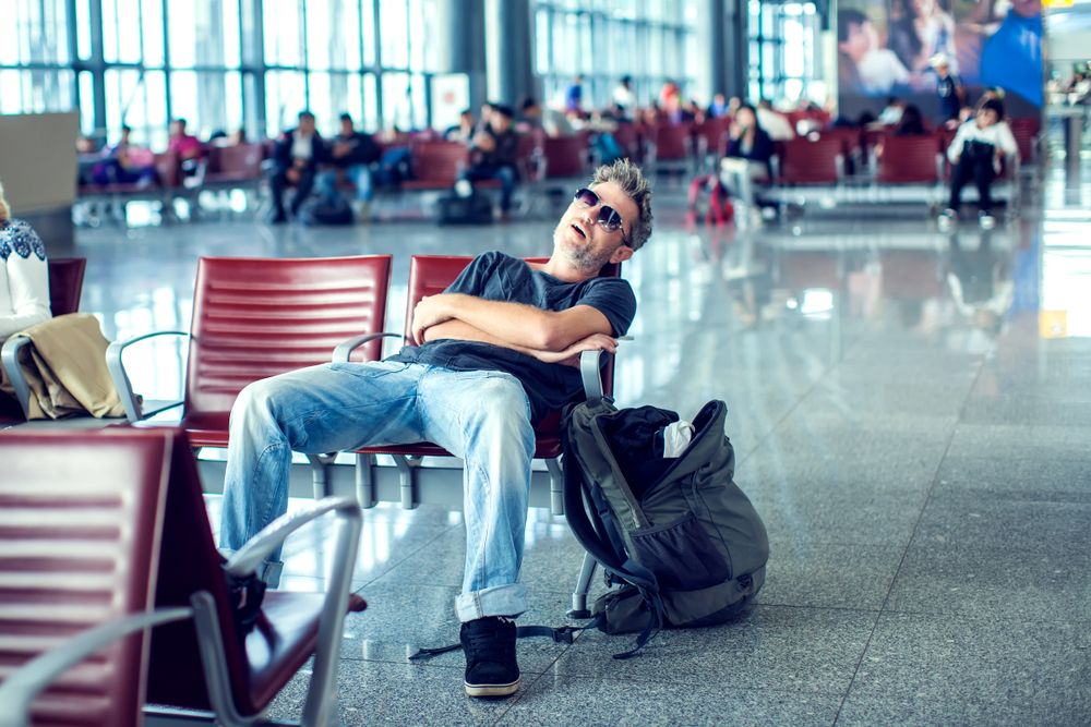 Man,With,Sunglasses,Sleeping,While,Sitting,In,Airport,Terminal,And