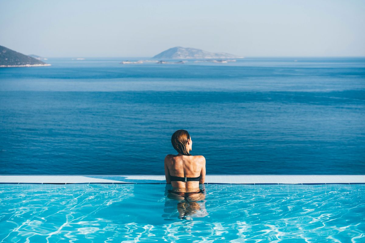 Woman in infinity pool admiring scenic view.
A globális vagyon aránytalanul oszlik meg a világon.