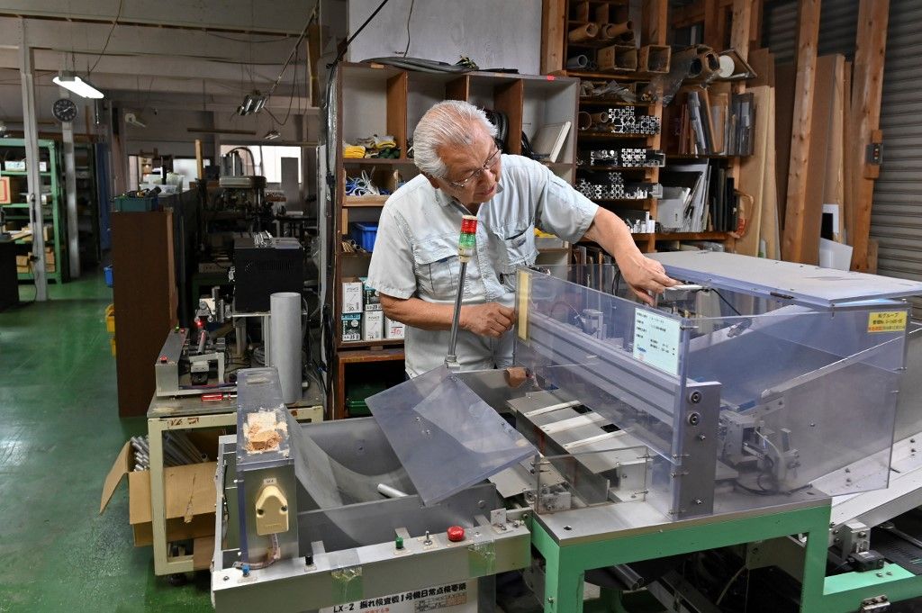 This photo taken on June 20, 2023 shows Kiyoshi Hashimoto, president of the machinery factory J&A Sakura, looking at equipment at his factory in Yachimata, Chiba prefecture. Kiyoshi Hashimoto's machinery factory outside Tokyo should be buzzing with industry. Instead, it's so quiet you can hear him practising the recorder. The 82-year-old entrepreneur founded his company nearly 40 years ago, but well past retirement age he has neither a successor nor a buyer for a business that retains loyal clients. (Photo by Kazuhiro NOGI / AFP) / TO GO WITH Japan-demographics-business,FOCUS by Hiroshi Hiyama