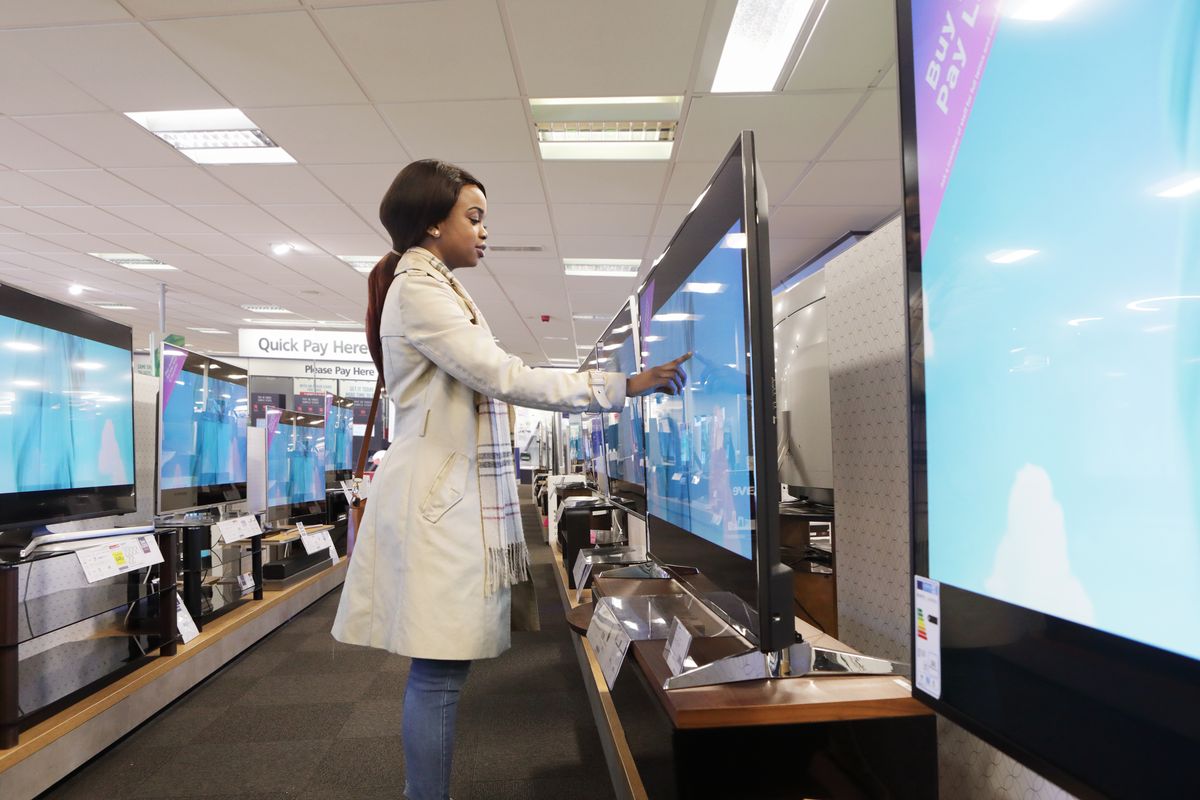 Young woman in shop looking at televisions