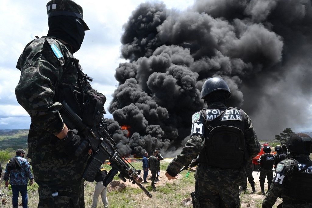 Members of the Honduran Military Police of Public Order stand guard during the incineration of 5.6 tonnes of cocaine in a military unit on the southern outskirts of Tegucigalpa on June 13, 2024. This is the second cocaine-burning operation in Honduras in 2024. On April 9, 1,350 kilos were confiscated and burned two weeks earlier by ten Hondurans detained on two boats in the jurisdiction of the insular department of Islas de la Bahia (Caribbean). (Photo by Orlando SIERRA / AFP)