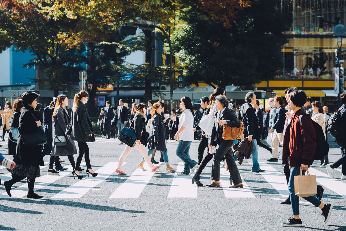 Crowd of busy commuters crossing street in Shibuya crossroad, Tokyo