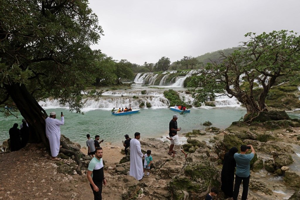 Locals and tourists tour the Wadi Darbat (Darbat Valley) near Salalah, in the southern Omani province of Dhofar on July 21, 2022. (Photo by Mohammed MAHJOUB / AFP)