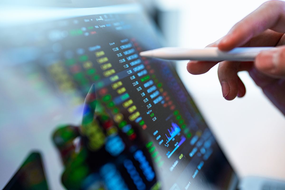 Market Analyze with Digital Monitor focus on tip of finger.