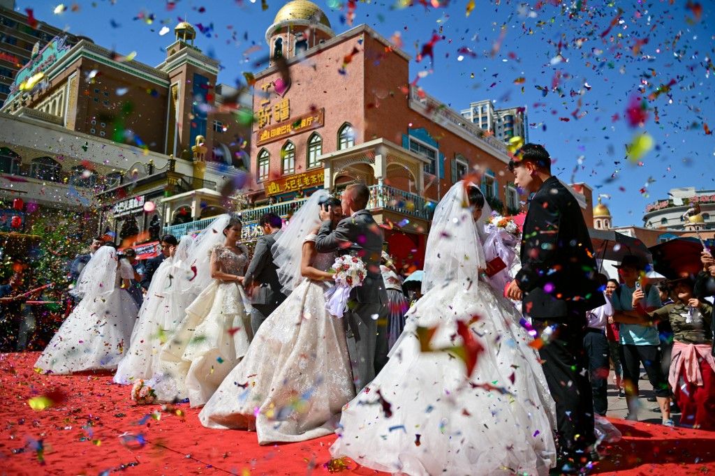 (240810) -- URUMQI, Aug. 10, 2024 (Xinhua) -- Newly-wed couples attend a group wedding at the Xinjiang International Grand Bazaar in Urumqi, northwest China's Xinjiang Uygur Autonomous Region, Aug. 10, 2024. The group wedding was held here on Saturday on the occasion of the Qixi Festival, also known Chinese Valentine's Day. (Xinhua/Ding Lei) (Photo by Ding Lei / XINHUA / Xinhua via AFP) ajándék
