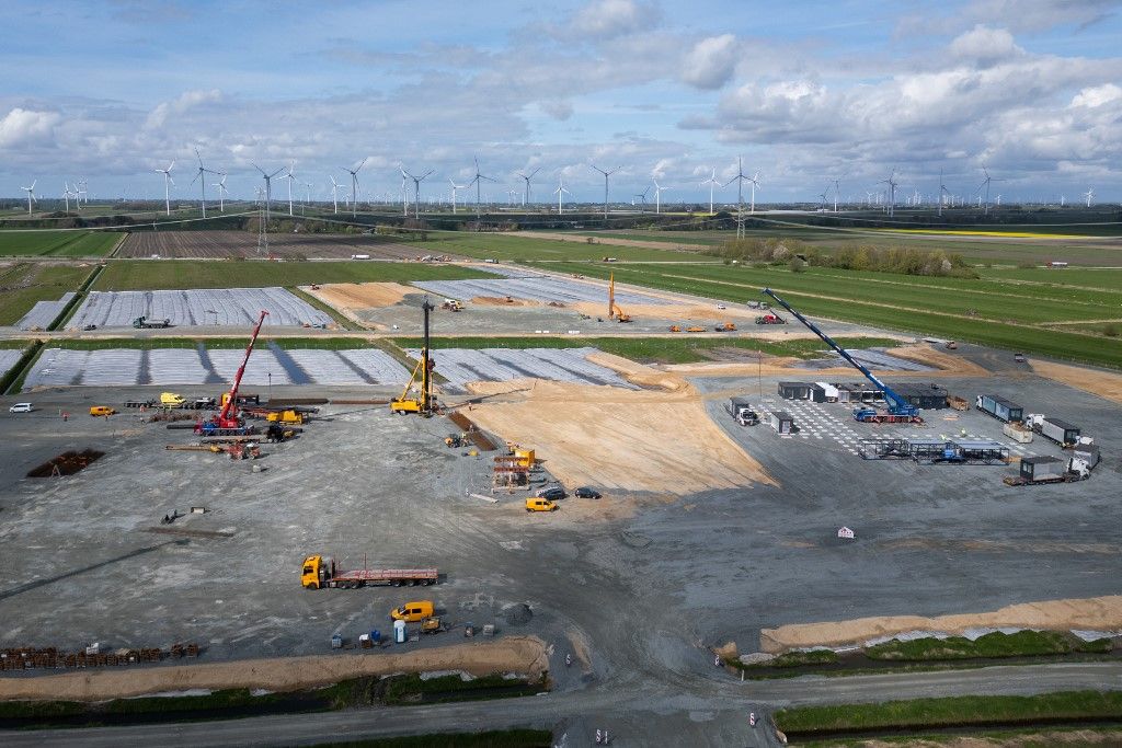 18 April 2024, Schleswig-Holstein, Heide: View of the Northvolt Three Gigafactory construction site (photo taken with a drone). Pile foundations (l) and the construction of a temporary modular system for office buildings (r) are taking place on the first construction site. On the outside right, asphalt work is taking place for a temporary highway exit for construction site operations. Northvolt AB plans to manufacture battery cells for electric cars at the factory in the Dithmarschen district from 2026. Photo: Christian Charisius/dpa (Photo by CHRISTIAN CHARISIUS / DPA / dpa Picture-Alliance via AFP)