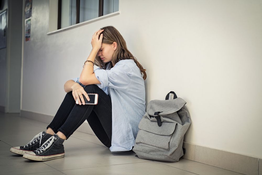 Upset,And,Depressed,Girl,Holding,Smartphone,Sitting,On,College,Campus
 15-24 évesek 45 százalékának van mentális betegsége a világon.