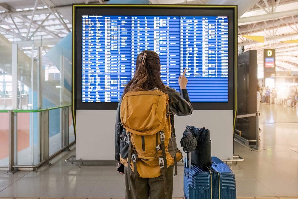 Portrait,Back,Of,A,Young,Asian,Woman,Checking,Flight,Times