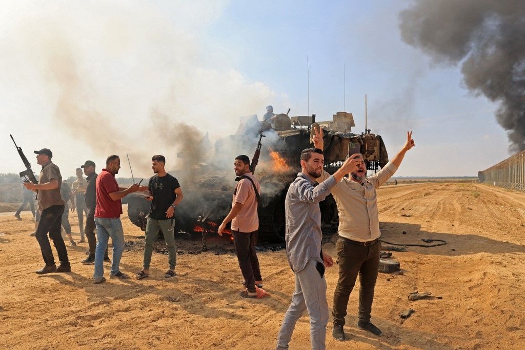 Palestinians take control of an Israeli Merkava battle tank after crossing the border fence with Israel from Khan Yunis in the southern Gaza Strip on October 7, 2023. Barrages of rockets were fired at Israel from the Gaza Strip at dawn as militants from the blockaded Palestinian enclave infiltrated Israel, with at least one person killed, the army and medics said. (Photo by SAID KHATIB / AFP) háború