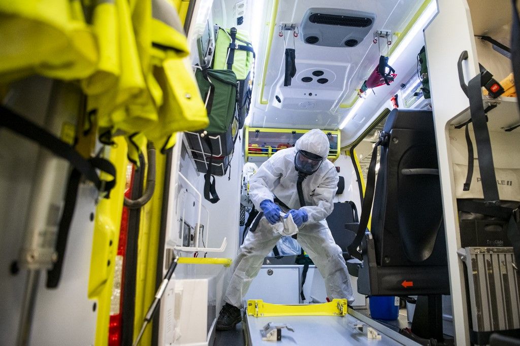 A healthcare worker cleans and disinfects an ambulance after dropping a patient at the Intensive Care Unit (ICU) at Danderyd Hospital near Stockholm on May 13, 2020, during the coronavirus COVID-19 pandemic. (Photo by Jonathan NACKSTRAND / AFP)