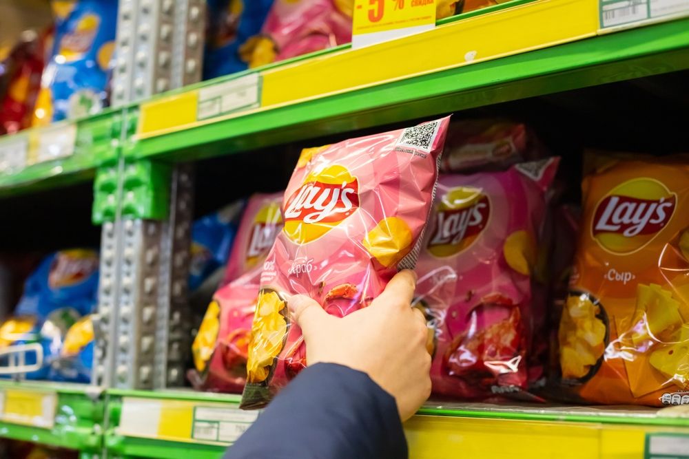 Lays,Potato,Chips,Packaging,On,Store,Shelf.,Man's,Male,Hand, chipsadó