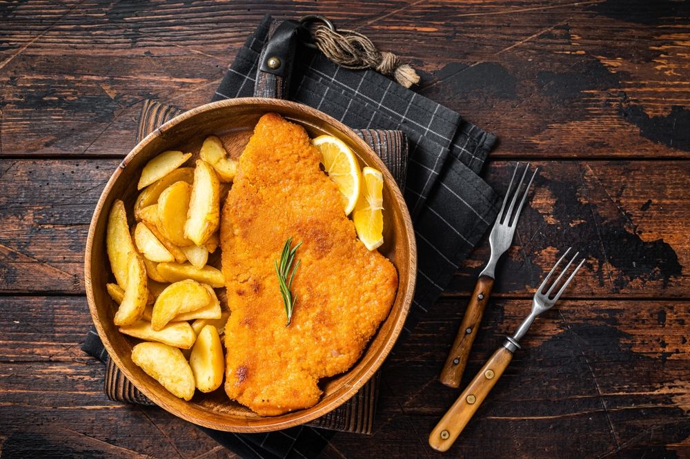 Austrian,Fried,Weiner,Schnitzel,With,Potato,Wedges,In,A,Wooden
rántotthús