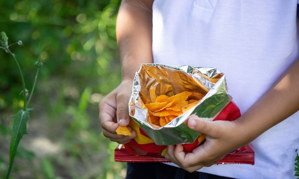 Little,Boy,Eats,Potato,Chips,From,A,Pack.,Selective,Focus, chipsadó