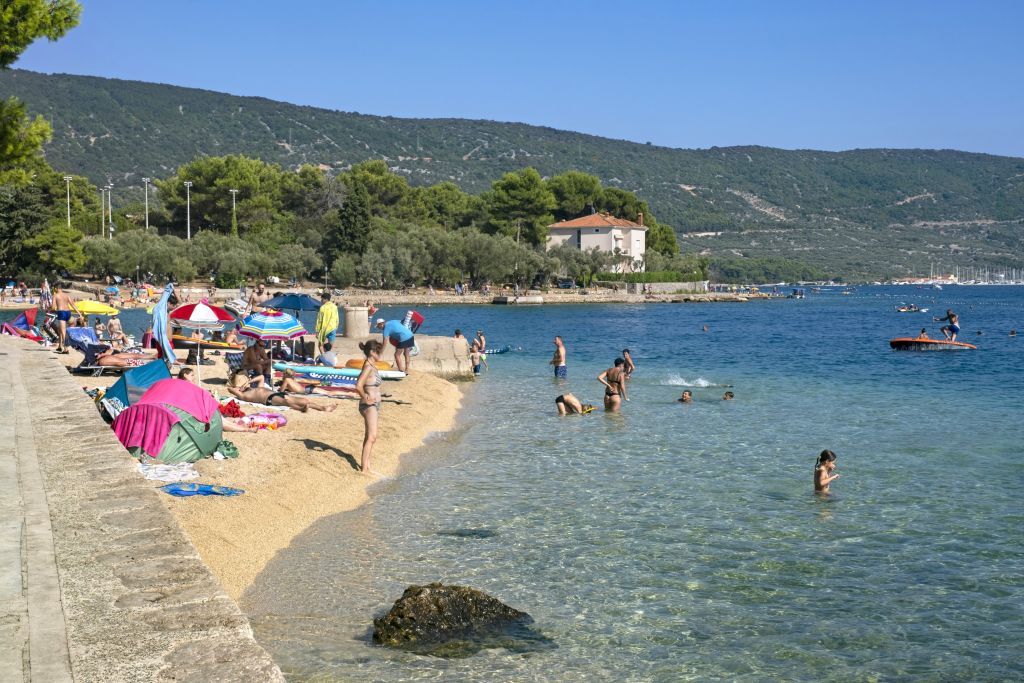 Sunbathers on sandy beach and tourists swimming in the Adriatic Sea near Cres on the island Cherso, Kvarner Bay, Primorje-Gorski Kotar, Croatia