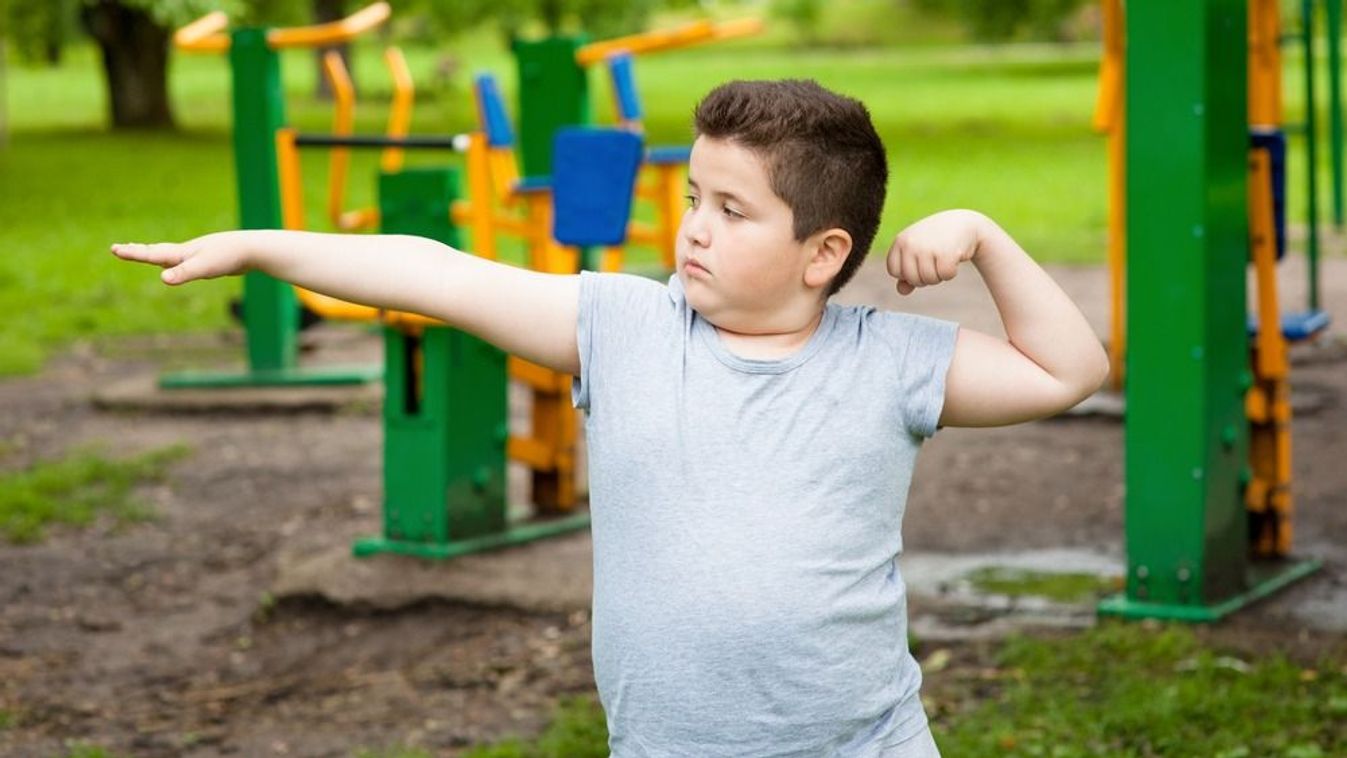 Fat,Boy,Shows,His,Muscles,In,The,Background,Of,Exercise