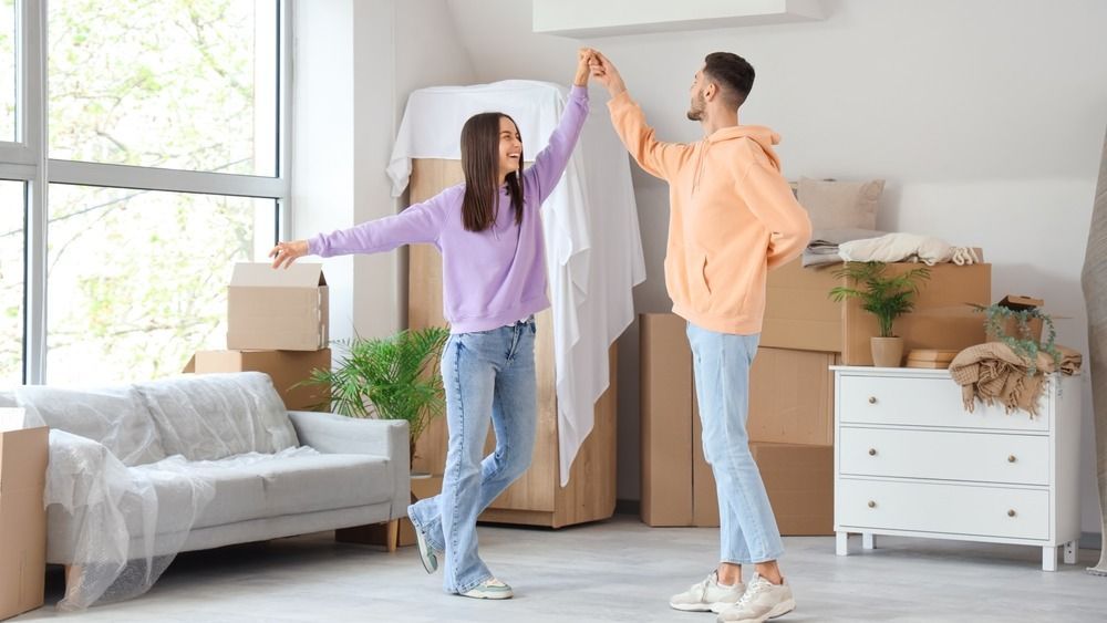 Young,Couple,Dancing,In,Room,On,Moving,Day