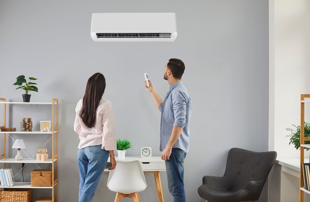 Young,Family,Couple,Switch,On,Modern,Air,Conditioning,System,At