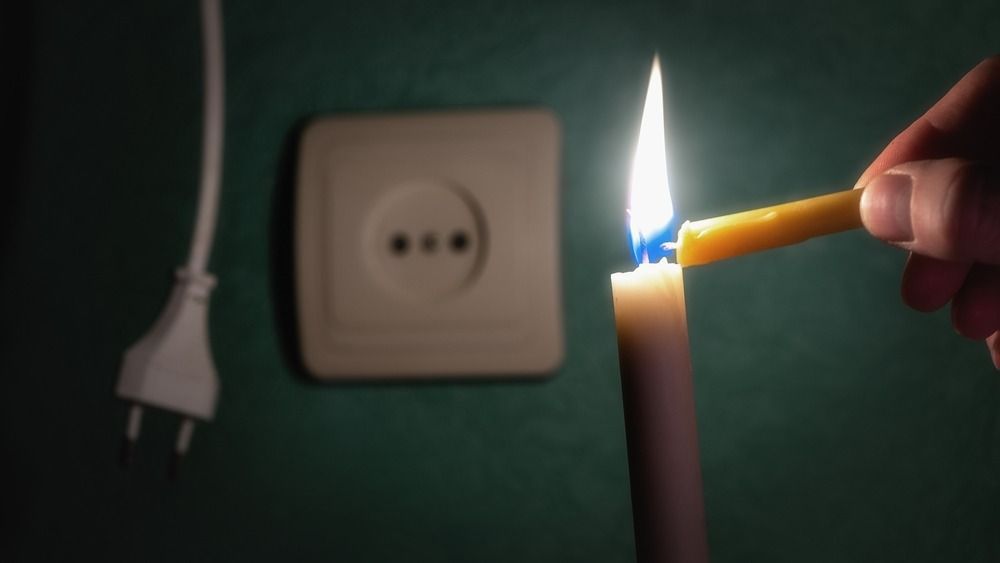 A,Burning,Candle,Next,To,An,Outlet,And,An,Electric
áramszünet, áramkimaradás, Ukrajna