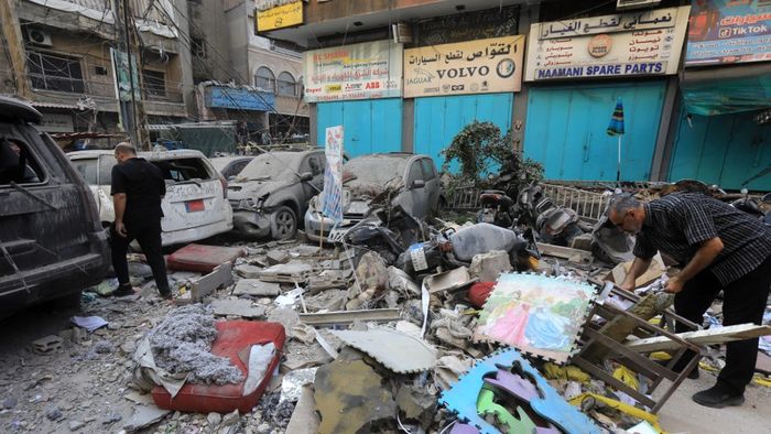 Debris lie around destroyed vehicles in a street under a residential building whose top two floors were hit by an Israeli strike in the Ghobeiri area of Beirut's southern suburbs on September 24, 2024. A Lebanese security source said on September 24 that an Israeli strike hit Hezbollah's south Beirut stronghold, as the Israel army confirmed it carried out the strike in the Lebanese capital without giving further details. (Photo by AFP)