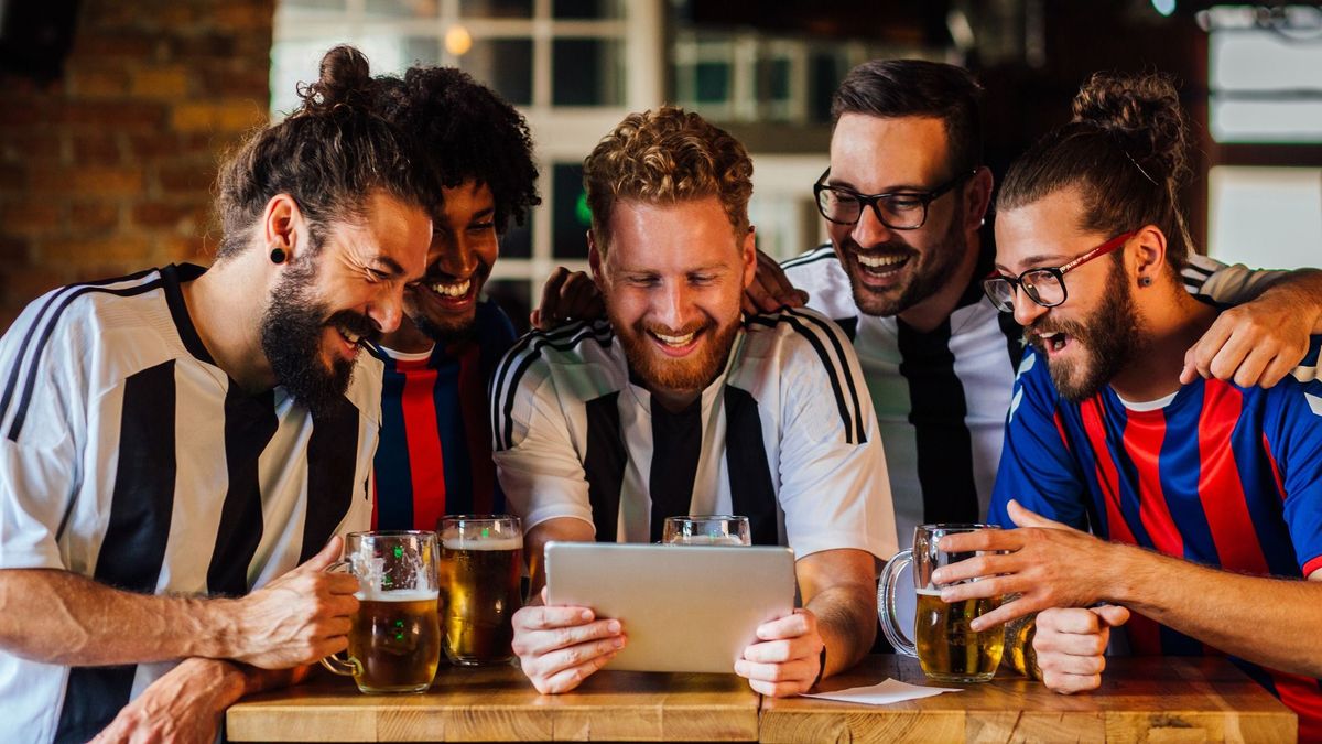 Group of friends watching the football game at the pub