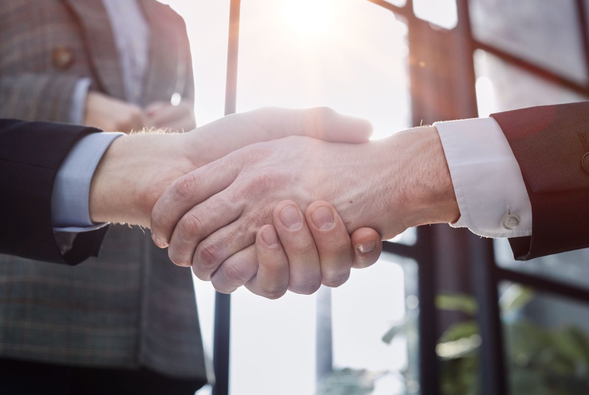 businessman shaking hands partnership deal business while standing indoors in the office, cégek létszámnövelési várakozása