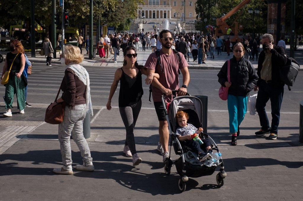 A couple with their child are walking at Syntagma square in Athens, Greece on November 3, 2022. (Photo by Nikolas Kokovlis/NurPhoto) (Photo by Nikolas Kokovlis / NurPhoto / NurPhoto via AFP)