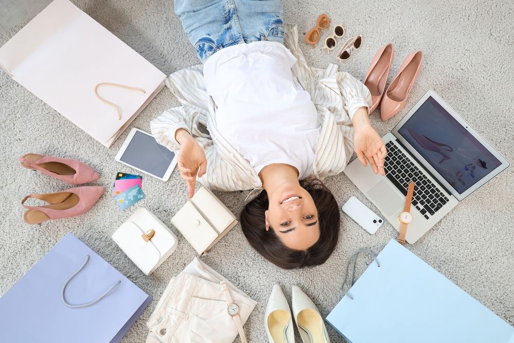 Young,Woman,With,Purchases,And,Gadgets,Lying,On,Floor,,Top