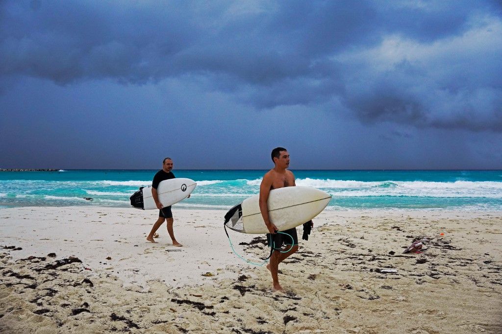 Surfers leave the beach ahead of the arrival of tropical storm Helene in Cancun, Quintana Roo state, Mexico on September 24, 2024. (Photo by Elizabeth Ruiz / AFP)