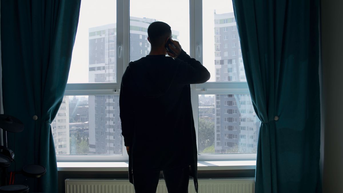 Silhouette of a business man talking on a mobile phone on the background of a window and city. Media. Successful confident businessman standing at home by the window., A bűnözők köztünk járnak: rengetegen szivárogtak be a legális gazdaságba