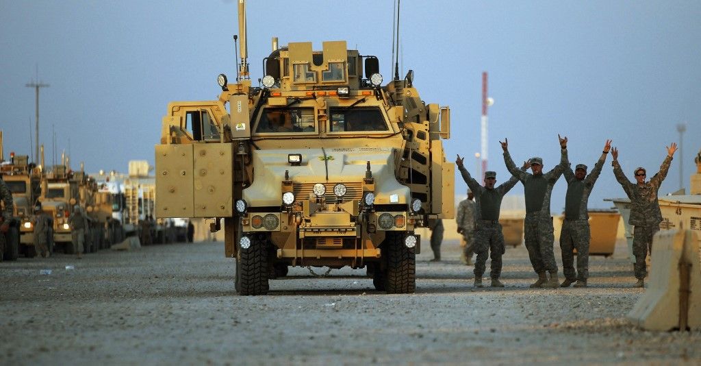 Soldiers from the 3rd Brigade, 1st Cavalry Division gesture while rejoicing in the convoy staging area before departing Camp Adder, now known as Imam Ali Base, on December 17, 2011 near Nasiriyah, Iraq.  Around 500 troops from the 3rd Brigade, 1st Cavalry Division ended their presence on Camp Adder, the last remaining American base, and departed in the final American military convoy out of Iraq, arriving into Kuwait in the early morning hours of December 18, 2011.  All U.S. troops were scheduled to have departed Iraq by December 31st, 2011.  At least 4,485 U.S. military personnel died in service in Iraq.  According to the Iraq Body Count, more than 100,000 Iraqi civilians have died from war-related violence.   AFP PHOTO / POOL / Mario TAMA (Photo by MARIO TAMA / POOL / AFP)